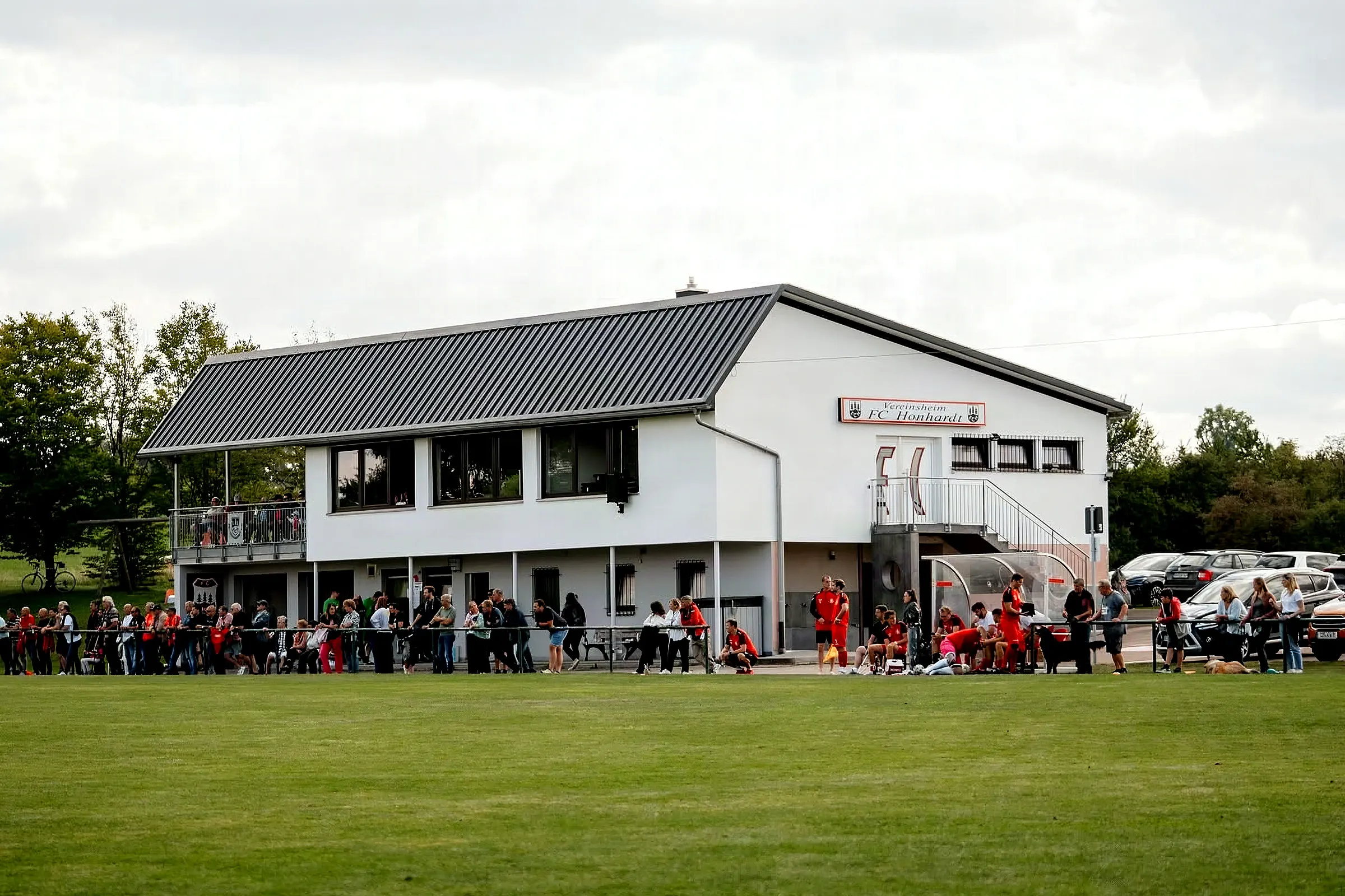 Vereinsheim am Spieltag, Zuschauer entlang des Sportplatzes